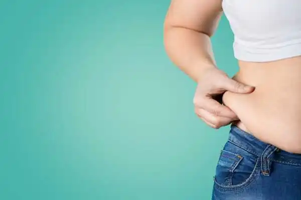 Image of woman pinching her love handles to show weight gain Chatham